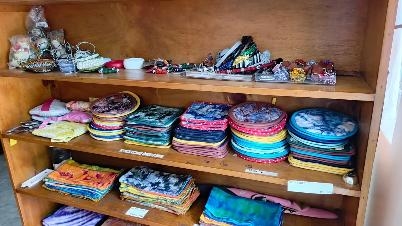 Colourful learner-made textiles and accessories displayed on shelves