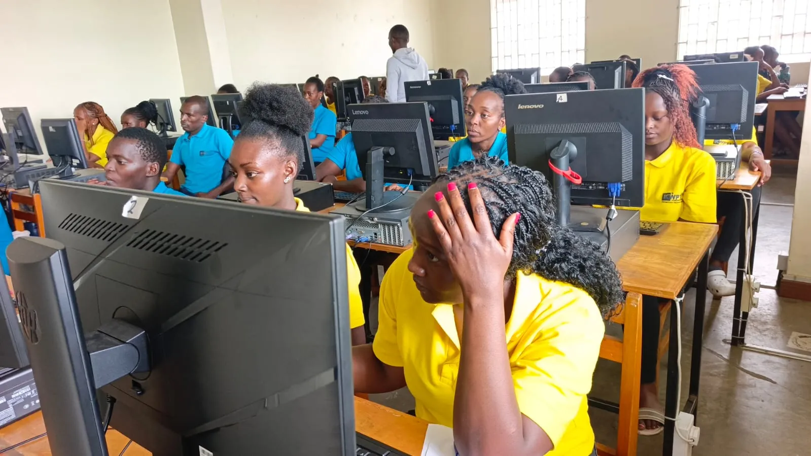 A busy KWPTI computer lab with students learning at desktop computers